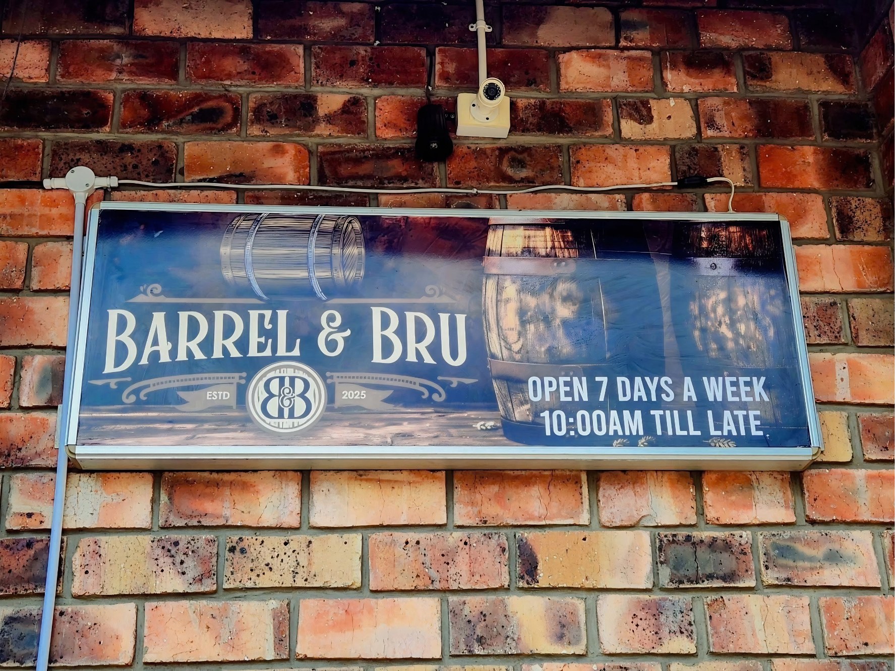 The Barrel & Bru sign on a brick wall
