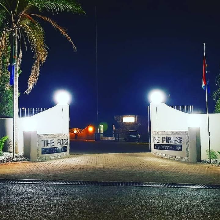 The Pines entrance gate lit up at night